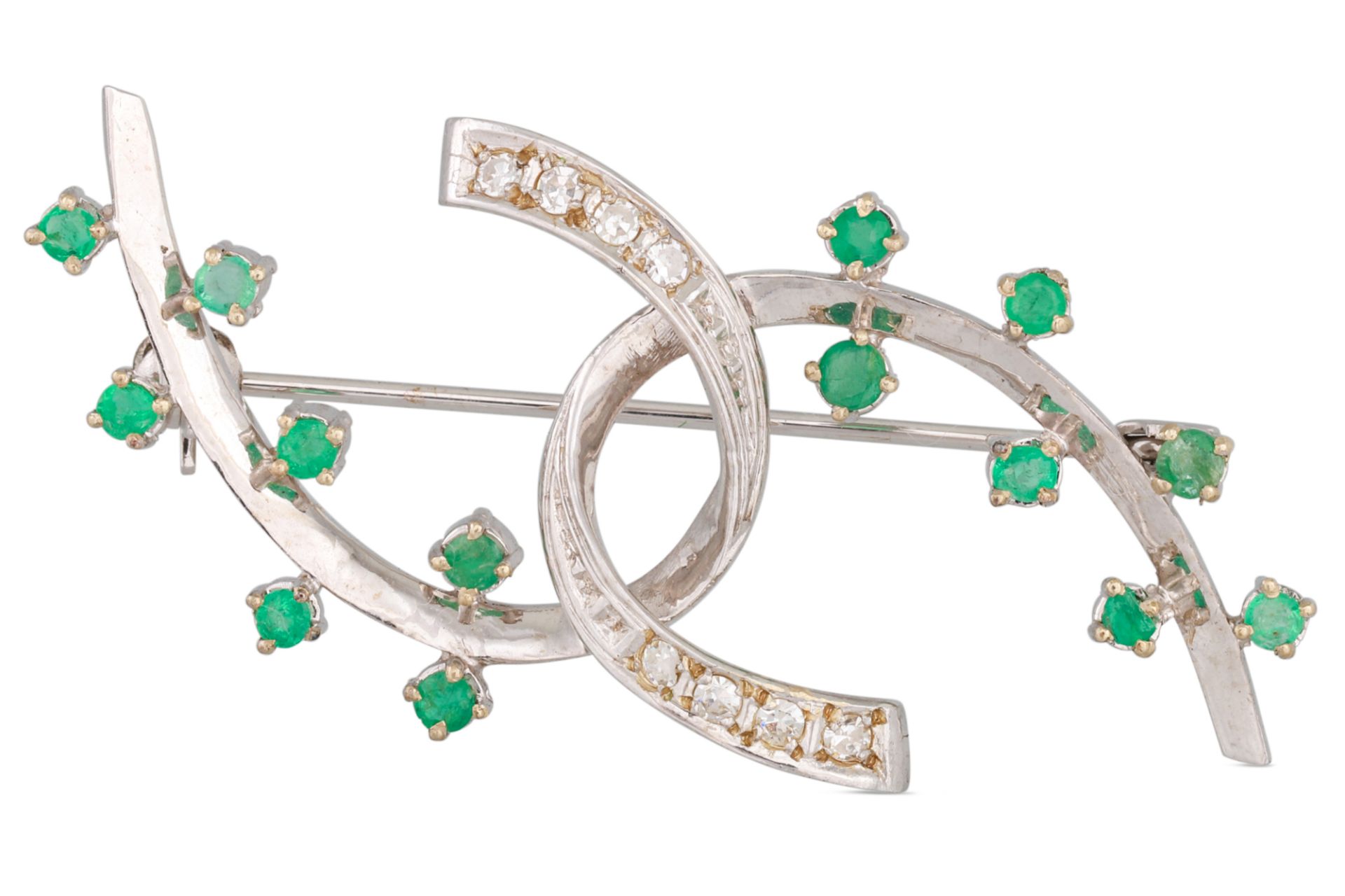 A DIAMOND AND EMERALD BROOCH, intertwined abstract form, mounted in 18ct white gold