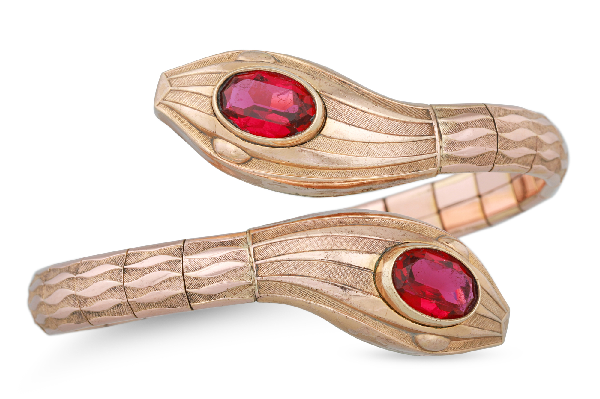 AN ART DECO ROLLED GOLD BRACELET, in the form of a snake, set with red glass, by Andreas Daub, ca