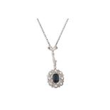 AN EDWARDIAN SAPPHIRE AND DIAMOND CLUSTER PENDANT, the cluster suspended from a diamond set bow to a