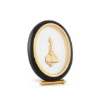 A JAEGER - LE COULTRE OVAL BLACK/GILT TABLE CLOCK, with mystery movement, ca 6.5" high, boxed with