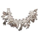 A LATE VICTORIAN SILVER CHARM BRACELET, suspending various charms