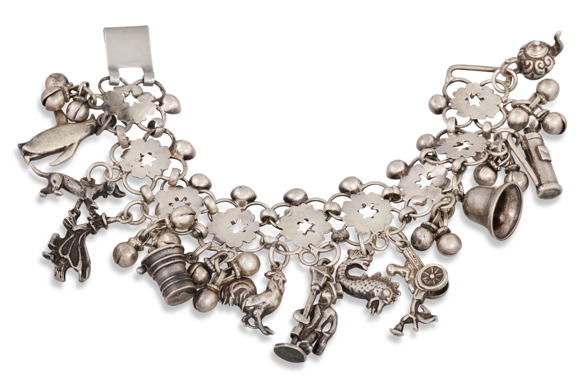 A LATE VICTORIAN SILVER CHARM BRACELET, suspending various charms