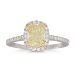 A DIAMOND CLUSTER RING, the fancy yellow cushion cut diamond to diamond surround and shoulders,