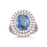 A SAPPHIRE AND DIAMOND CLUSTER RING, the oval sapphire to a two rowed diamond surround and