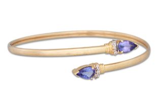 A TANZANITE AND DIAMOND SET BANGLE, mounted in 14ct gold