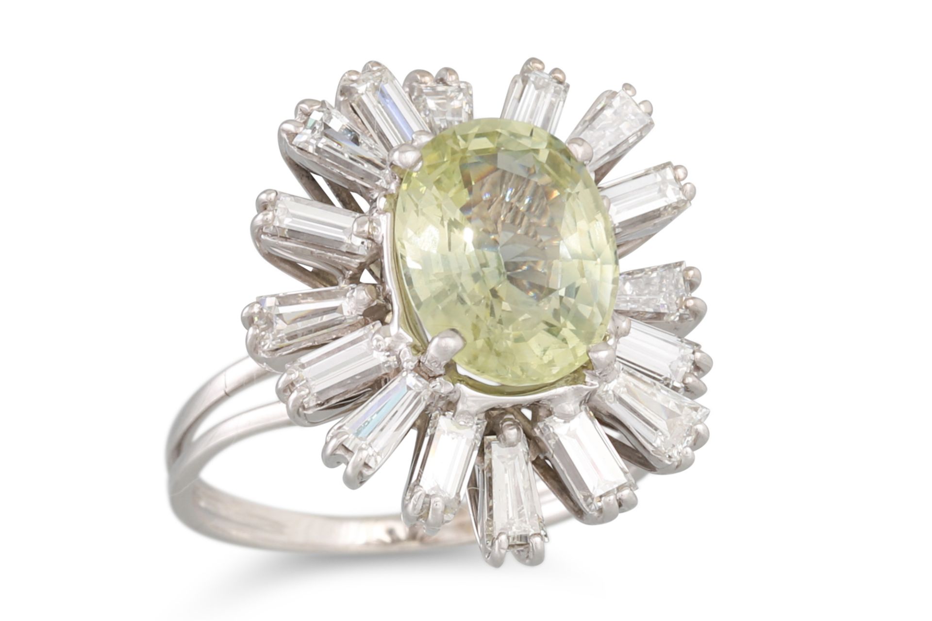A YELLOW SAPPHIRE AND DIAMOND CLUSTER RING, the oval sapphire to a ballerina style baguette cut