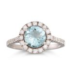AN AQUAMARINE AND DIAMOND CLUSTER RING, the circular aquamarine to diamond surround and shoulders,