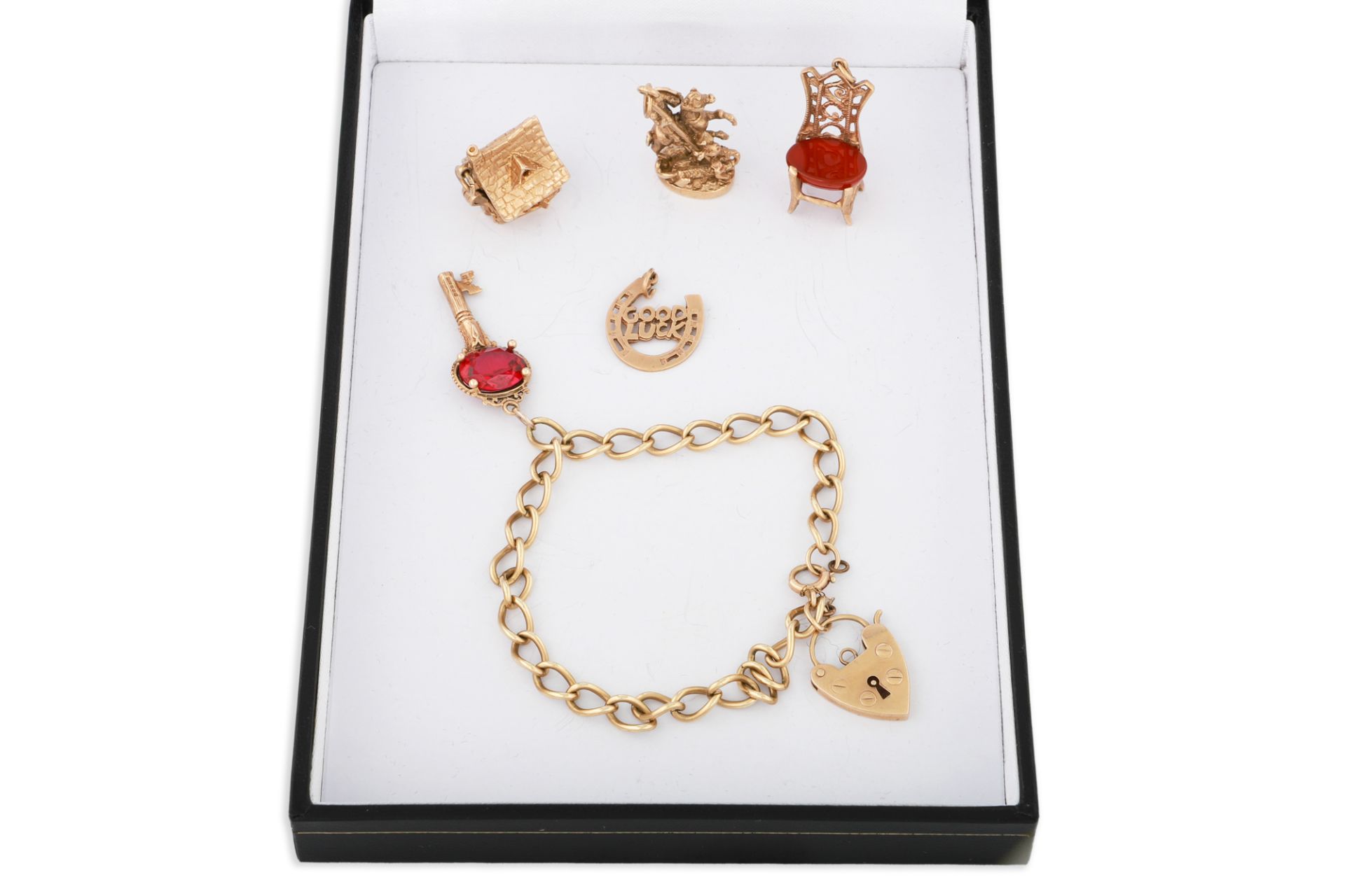 A 9CT GOLD CHARM BRACELET, various charms, 33 g.