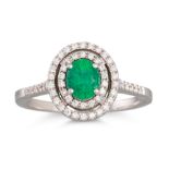 AN EMERALD AND DIAMOND CLUSTER RING, the oval emerald to a two rowed diamond surround and shoulders,
