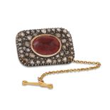 AN ANTIQUE CABOCHON GARNET AND ROSE CUT DIAMOND BROOCH, safety chain • Approx. 1.1" x 0.80"