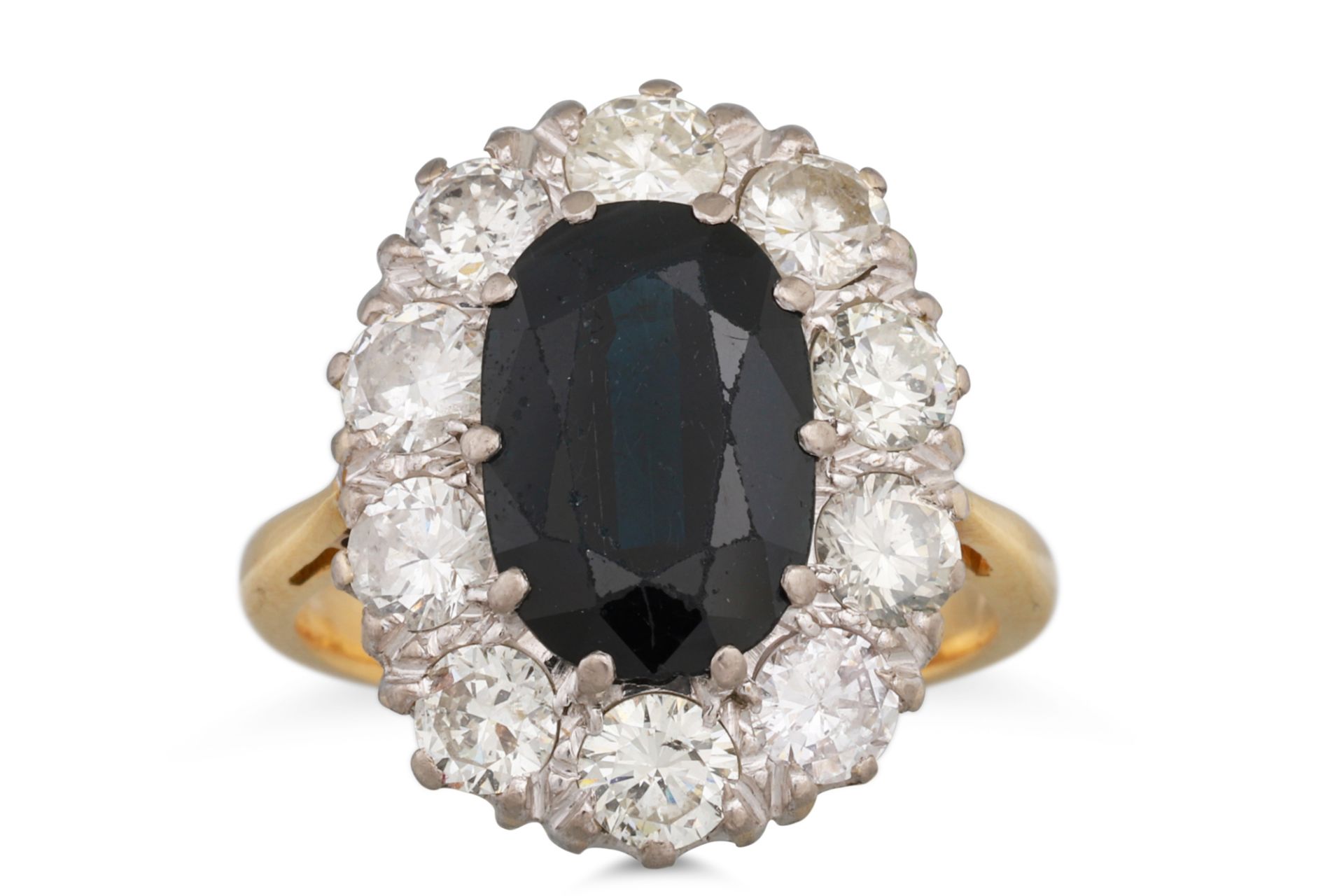 A DIAMOND AND SAPPHIRE CLUSTER RING, the oval sapphire to brilliant cut diamond surround, mounted in