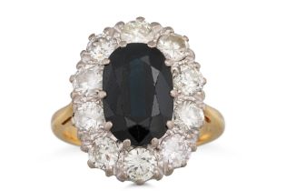 A DIAMOND AND SAPPHIRE CLUSTER RING, the oval sapphire to brilliant cut diamond surround, mounted in