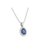 A SAPPHIRE AND DIAMOND PENDANT, the oval sapphire to diamond surround, mounted in 18ct white gold,
