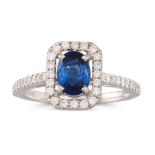 A DIAMOND AND SAPPHIRE CLUSTER RING, the oval sapphire to brilliant cut surround and shoulders,