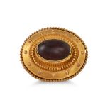 AN ANTIQUE GOLD PLATED BROOCH, Etruscan style, set with a cabochon garnet