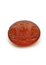 A ROMAN CARNELIAN INTAGLIO SHOWING AN EAGLE, SCORPION, ZEUS AMMON AND SERAPIS, 1ST-2ND CENTURY AD