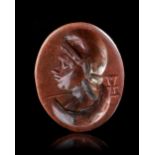 A ROMAN RED JASPER INTAGLIO WITH A BUST OF MEN, 1ST-2ND CENTURY AD