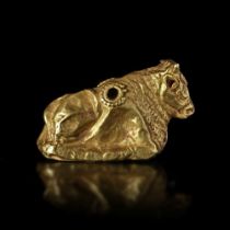 AN EAST GREEK GOLD REPOUSSE RECLINING BULL, 6TH/7TH CENTURY BC