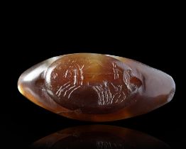 A SARDONYX CARVED BEAD WITH AN INTAGLIO OF A BIGA ADDED IN ROMAN TIMES, 1ST MILLENIUM BC AND 2ND CEN