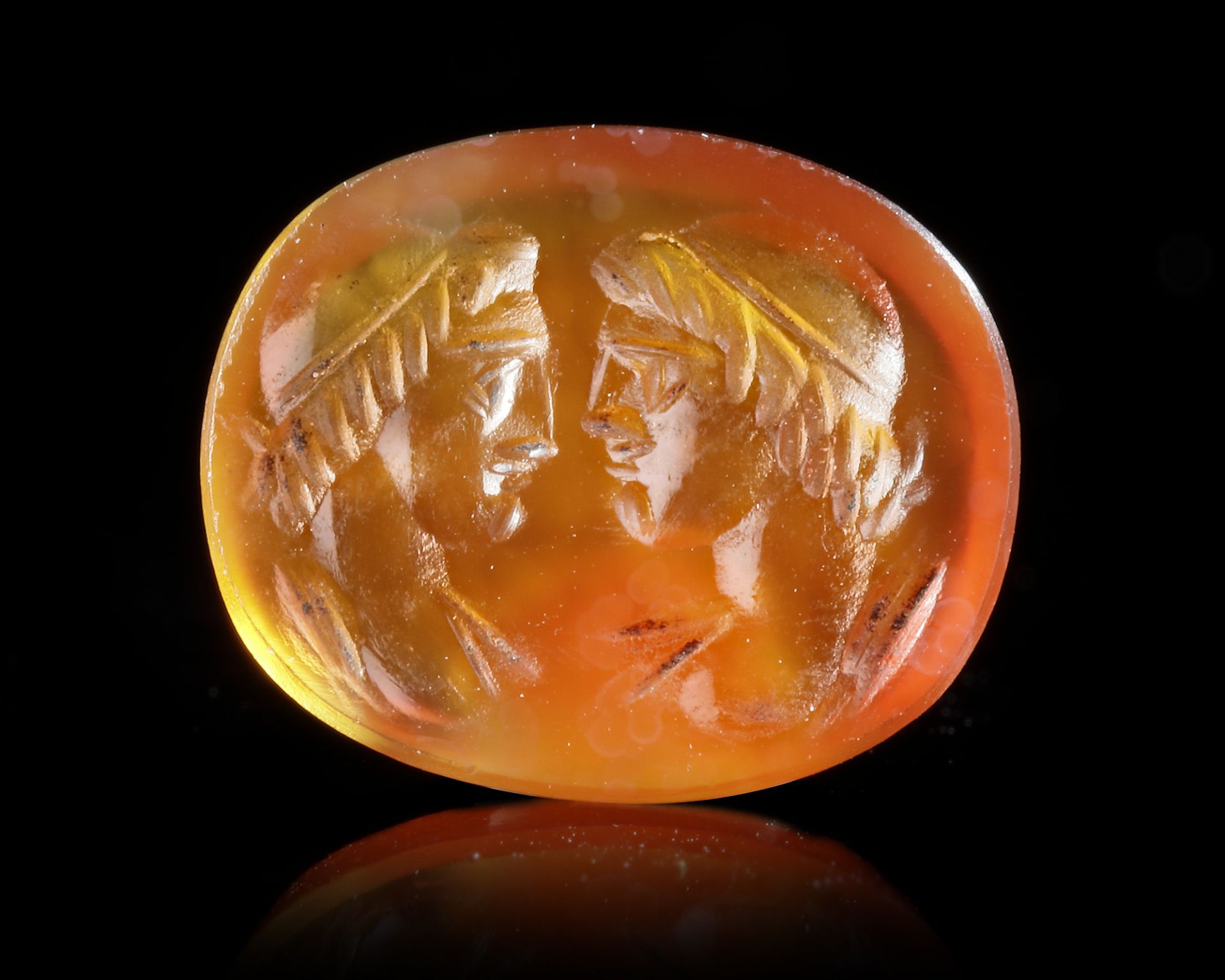 A ROMAN CARNELIAN INTAGLIO SHOWING THE BUSTS OF THE DIOSCURI, 1ST CENTURY AD