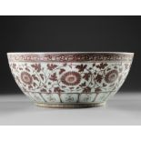 A LARGE CHINESE COPPER-RED 'FLORAL SCROLL' BOWL, QING DYNASTY (1644-1912)