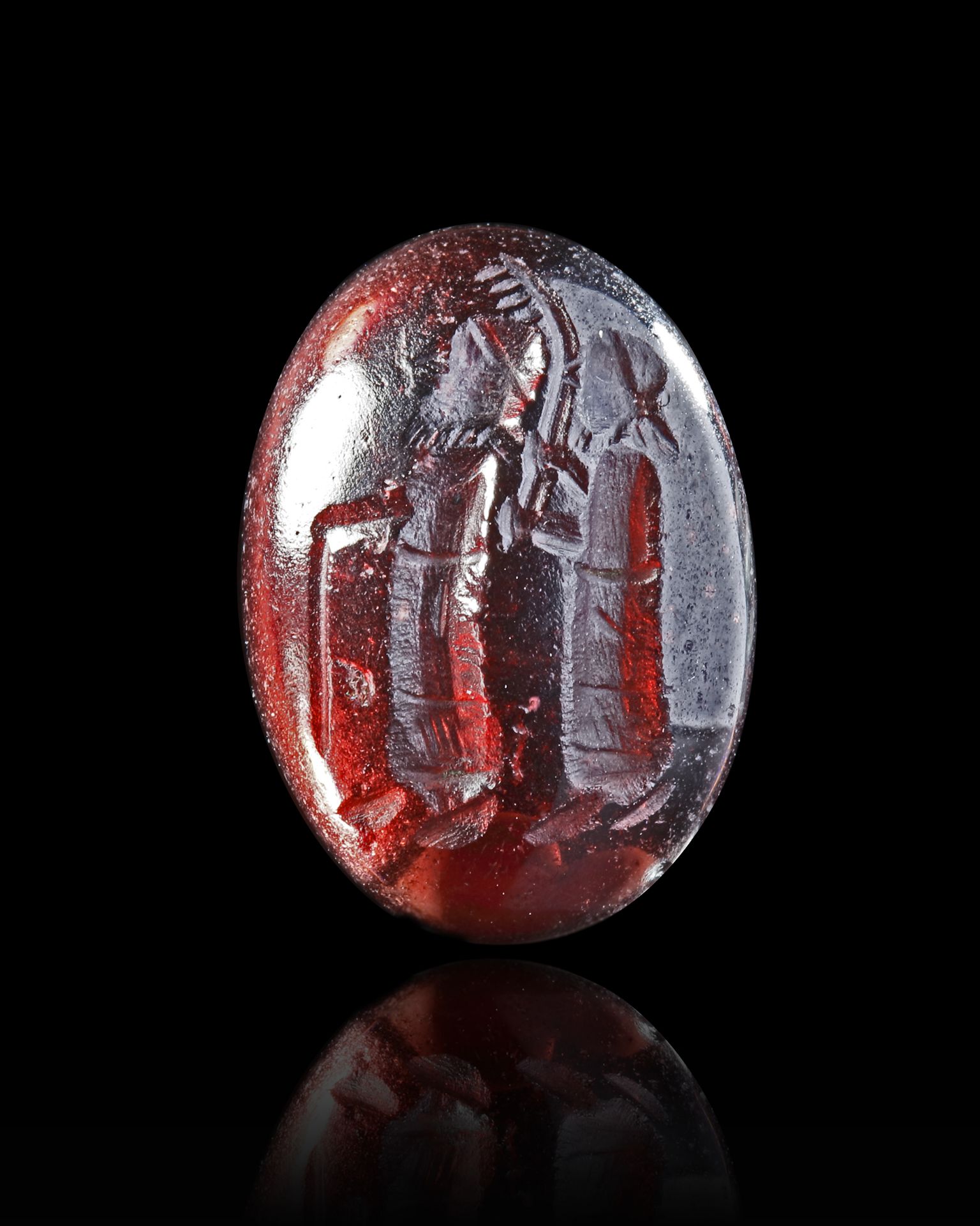 A GARNET CABOUCHON INTAGLIO, WITH TWO STANDING FIGURES, 2ND-3RD CENTURY AD