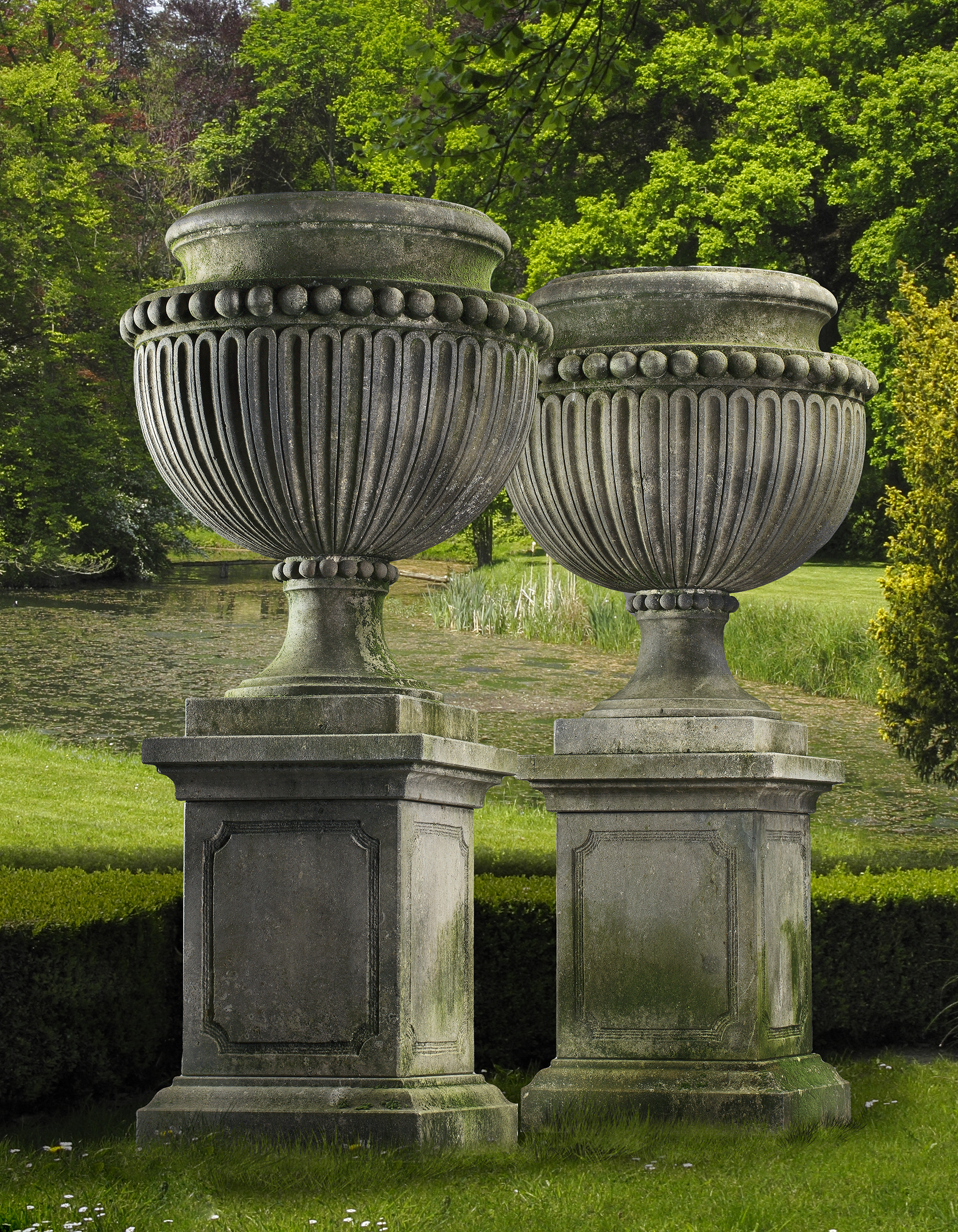 A PAIR OF LARGE AND IMPRESSIVE CARVED LIMESTONE GARDEN URNS ON PLINTHS IN IMPERIO TASTE, LATE 20TH C