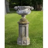 A LATE 19TH CENTURY COMPOSITION STONE VASE ON A COMPOSITION STONE DECORATED OCTAGONAL PEDESTAL