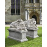 A PAIR OF SCULPTED LIMESTONE MODELS OF SLEEPING LIONS, MID 20TH CENTURY, LOOSELY AFTER THE MANNER OF