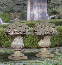 A PAIR OF LIMESTONE PIER FINIALS IN THE FORM OF FLOWER/FRUIT BASKETS, 20TH CENTURY