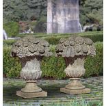 A PAIR OF LIMESTONE PIER FINIALS IN THE FORM OF FLOWER/FRUIT BASKETS, 20TH CENTURY