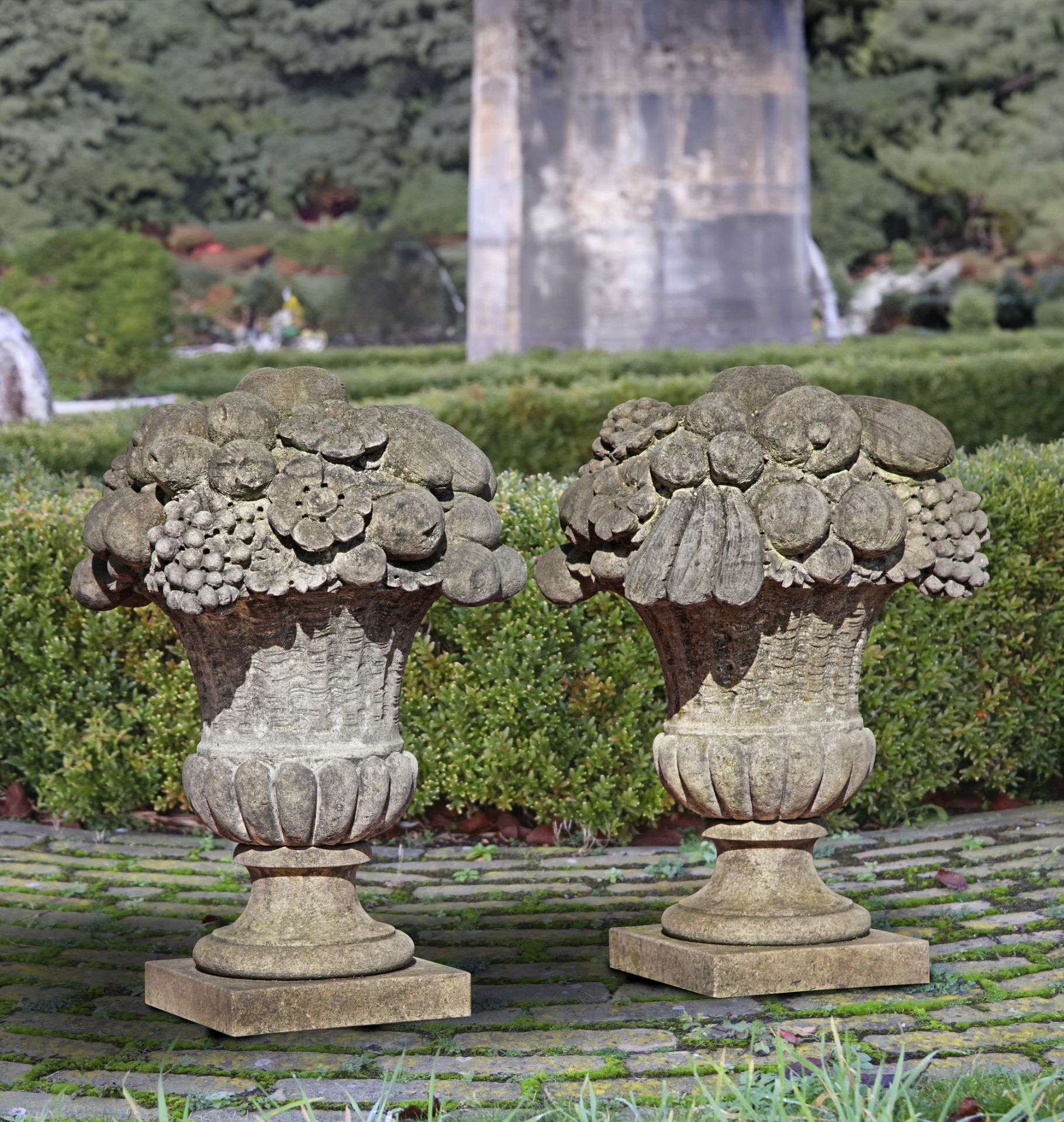 A PAIR OF LIMESTONE PIER FINIALS IN THE FORM OF FLOWER/FRUIT BASKETS, 20TH CENTURY