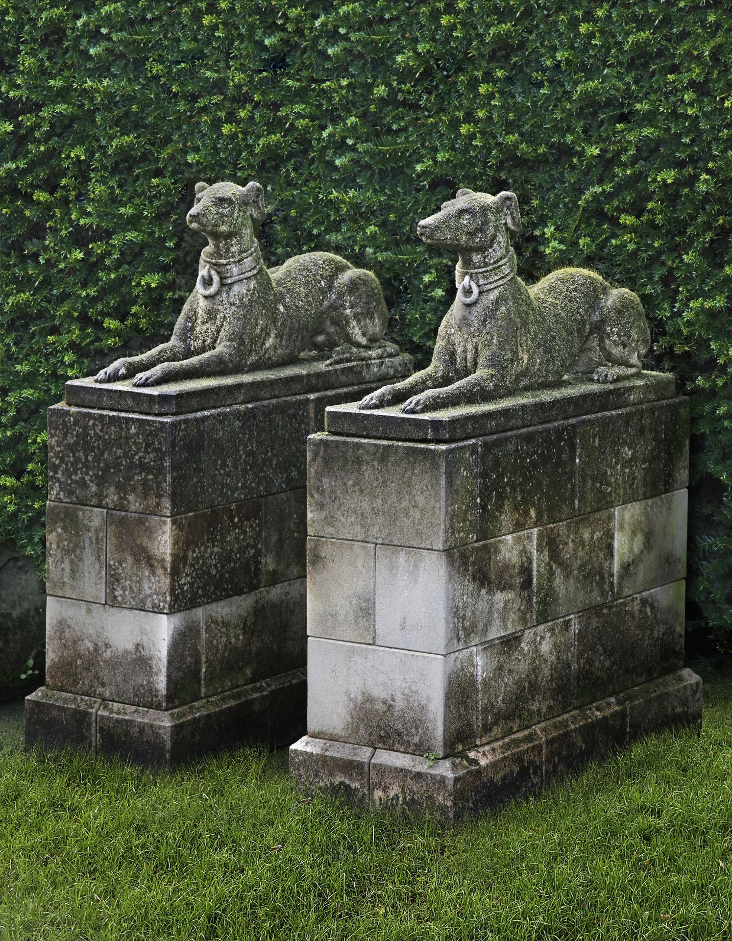 A PAIR OF SCULPTED LIMESTONE MODELS OF RECUMBENT HOUNDS, SECOND HALF 20TH CENTURY