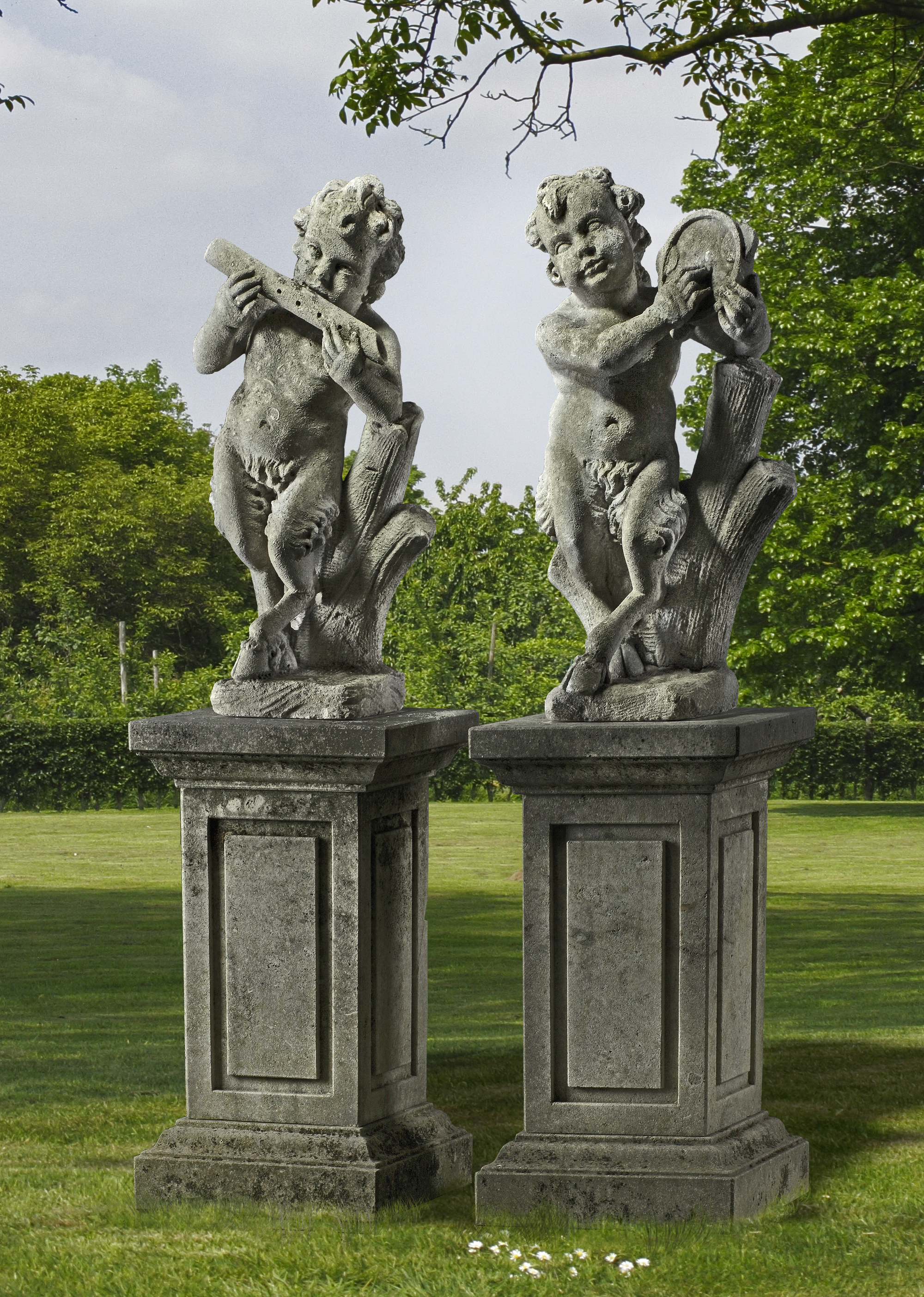 A PAIR OF CONTINENTAL SCULPTED LIMESTONE MODELS OF INFANT MUSICIAN FAUNS, LATE 19TH OR EARLY 20TH CE