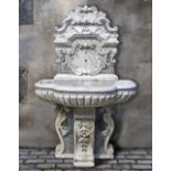A CARVED WHITE AND SPECIMEN MARBLE WALL FOUNTAIN, 19TH CENTURY