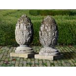 A PAIR OF CARVED LIMESTONE PIER FINIALS 19TH CENTURY, ON A LATER PLINTH