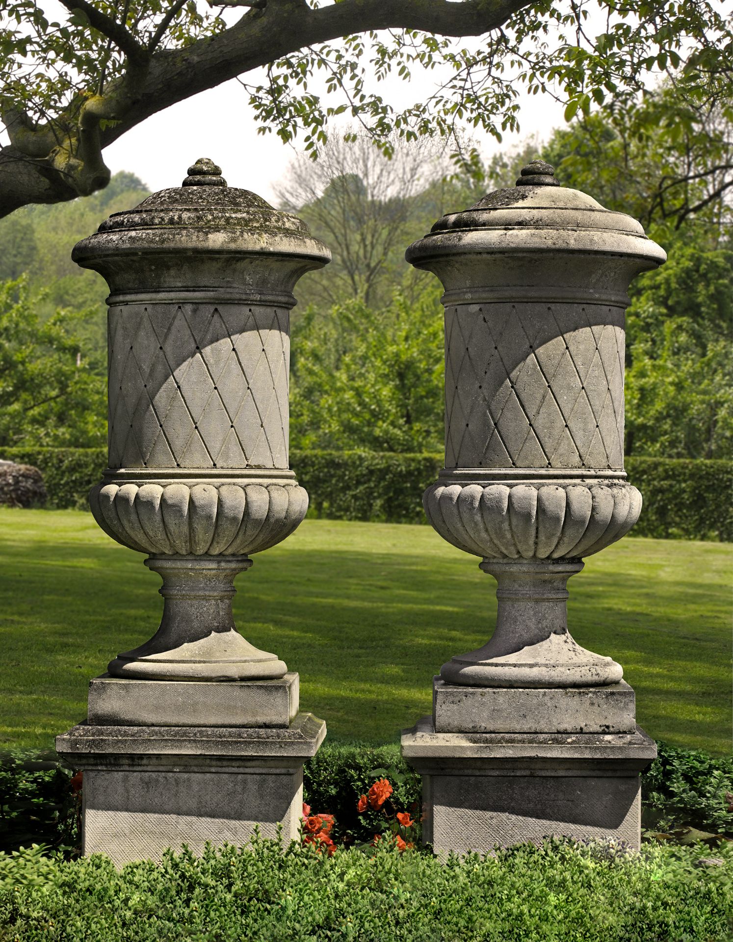 A PAIR OF SUBSTANTIAL CARVED LIMESTONE PEDESTAL URNS SECOND HALF 20TH C