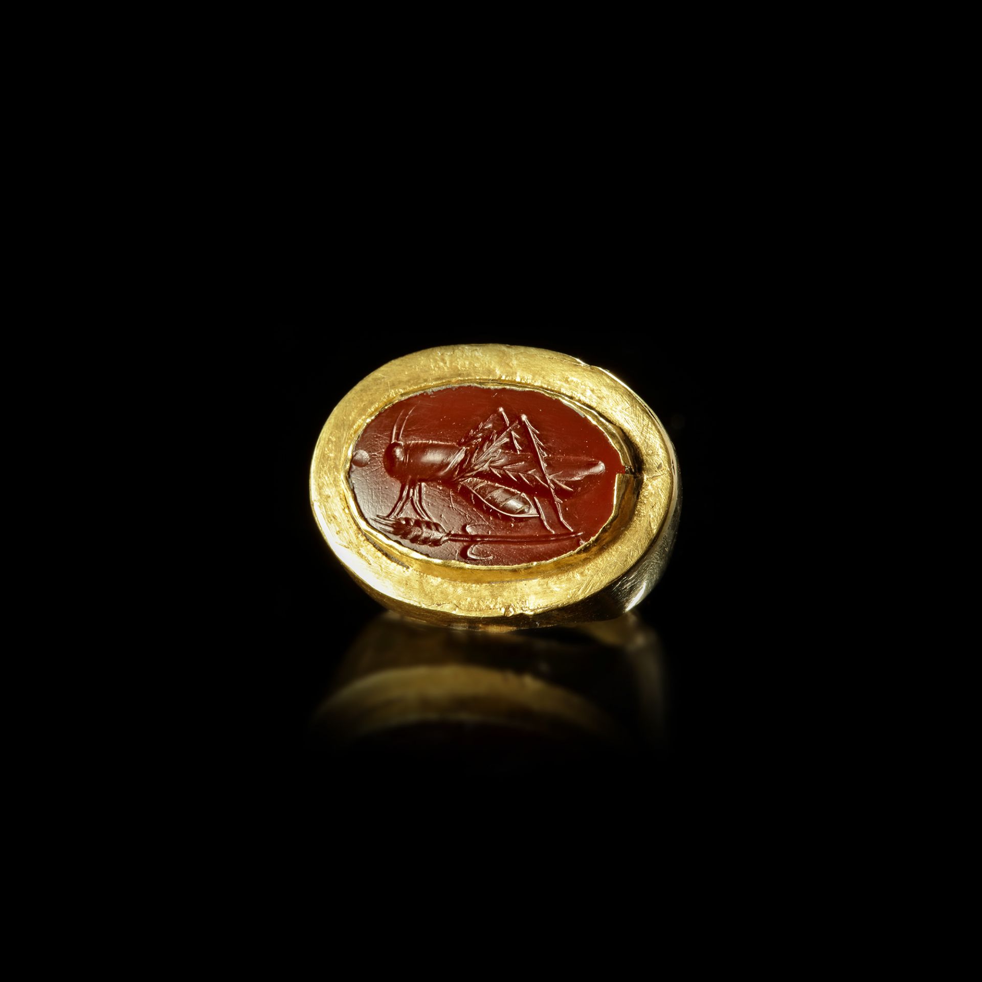 A HELLENISTIC GOLD RING WITH AN INTAGLIO SHOWING A LOCUST, 2ND-3RD CENTURY BC