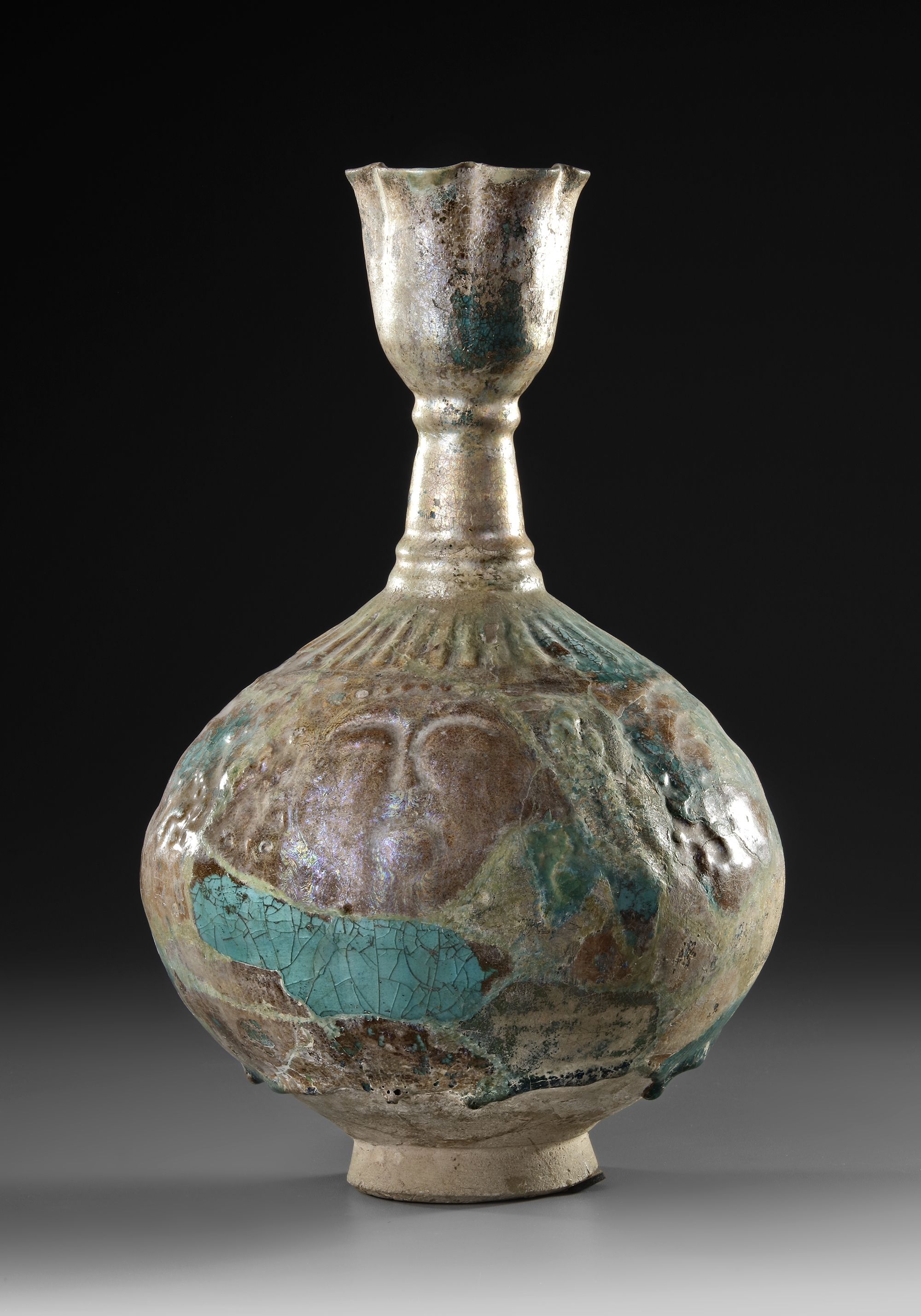 A KASHAN TURQUOISE GLAZED MOULDED BOTTLE VASE, PERSIA, 12TH CENTURY