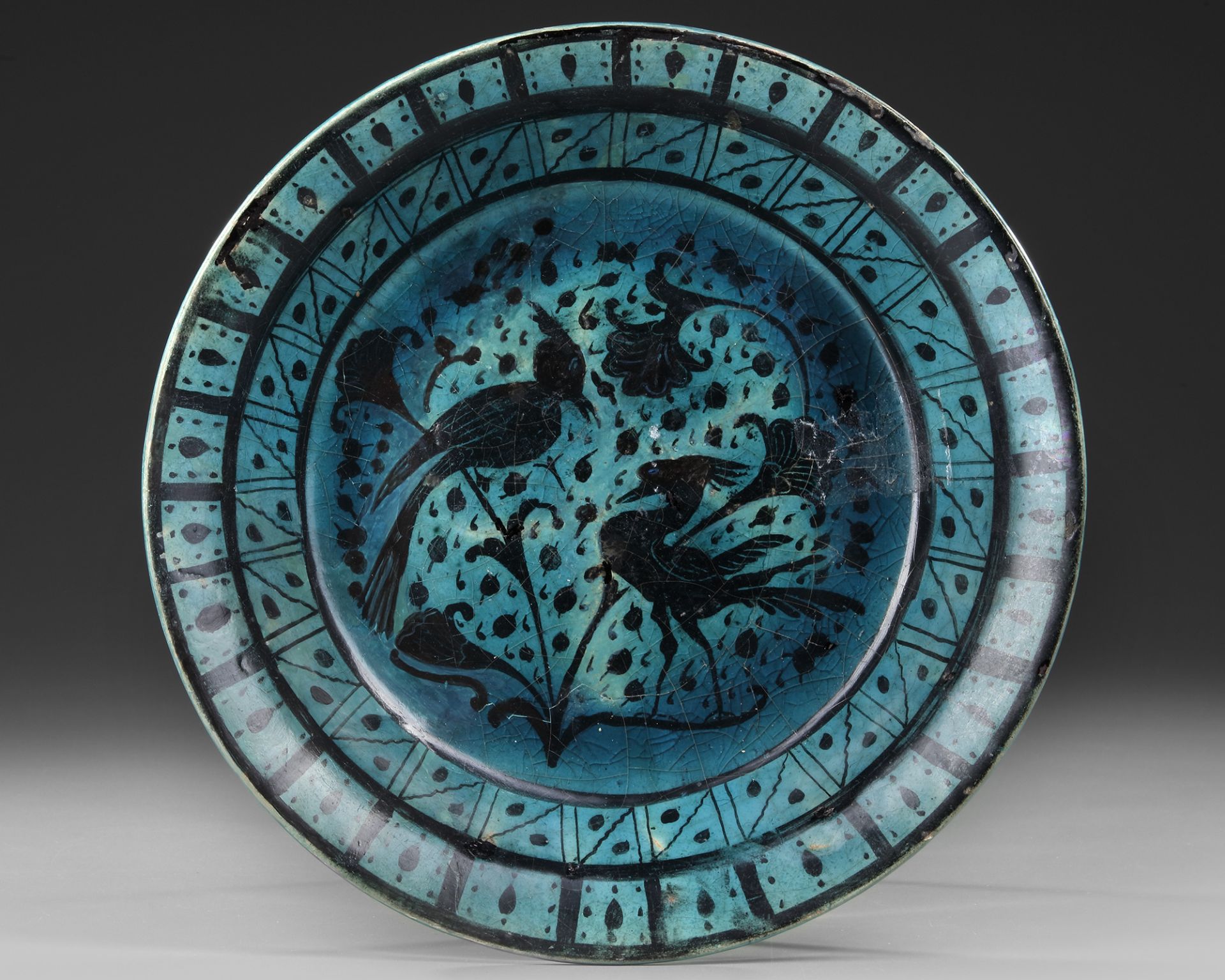 A RAQQA TURQUOISE-GLAZED POTTERY DISH, SYRIA, EARLY 13TH CENTURY