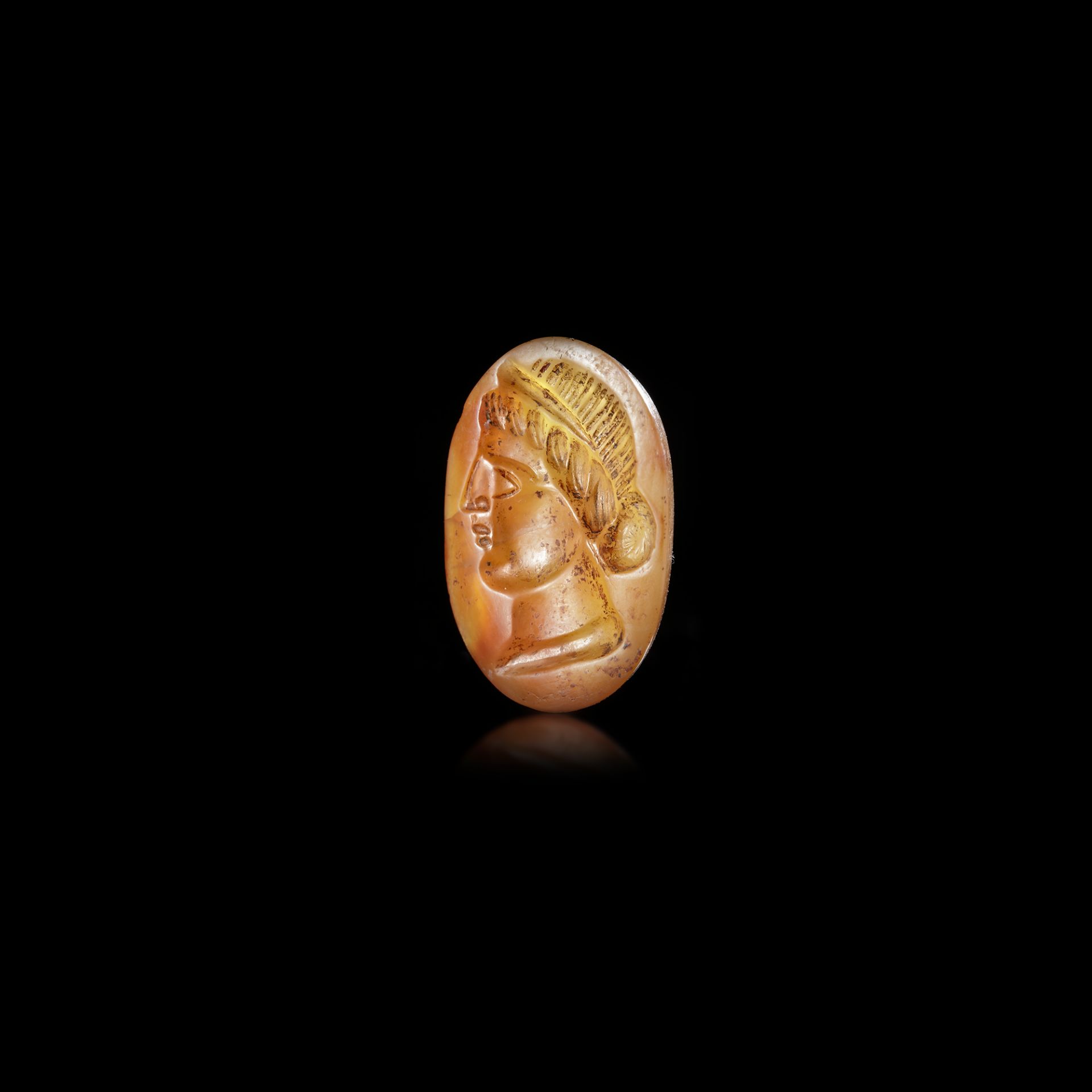 A CARNELIAN INTAGLIO IN THE ROMAN STYLE WITH A HEAD OF A WOMAN LEFT, 2ND CENTURY AD OR LATER