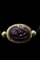 A CABOCHON GARNET WITH LEDA AND SWAN IN A GOLD MOUNT - WITH REPORT
