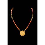 PTOLEMAIC PERIOD CARNELIAN AND GOLD NECKLACE WITH SUN PENDANT