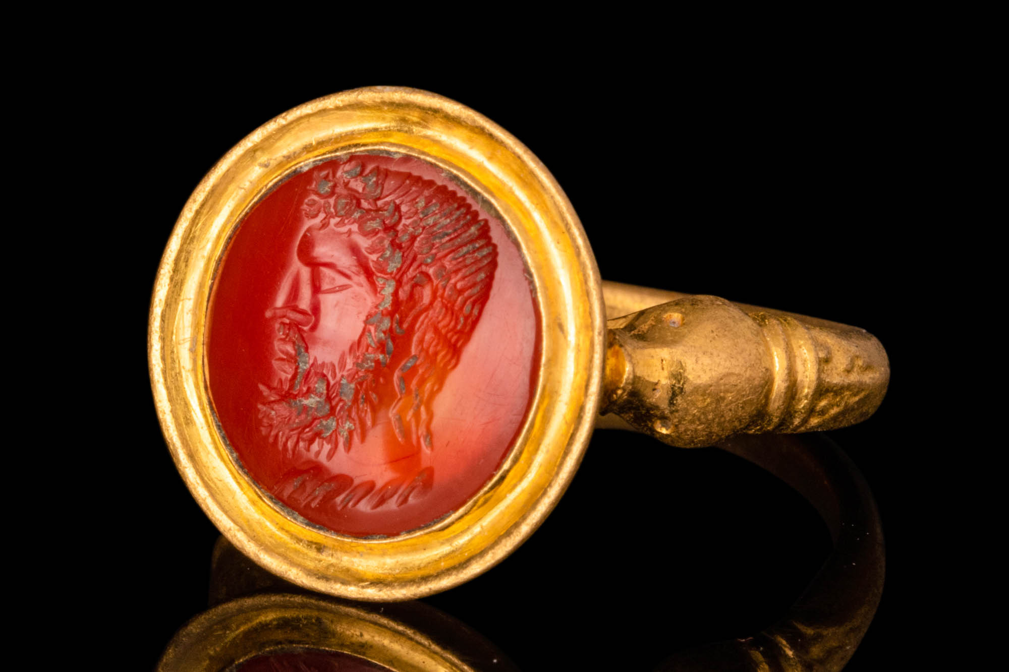 LATE HELLENISTIC GOLD FINGER RING WITH CARNELIAN INTAGLIO OF A BEARDED MAN