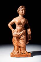 GREEK TERRACOTTA FIGURINE OF A STANDING DRESSED WOMAN