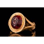 ROMAN GARNET INTAGLIO DEPICTING AN HEAD OF PUTTO IN GOLD RING