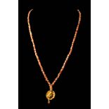 PTOLEMAIC PERIOD CARNELIAN NECKLACE WITH GOLD PENDANT