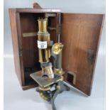 Brass monocular microscope marked ' Baker, of London' in fitted wooden case with additional