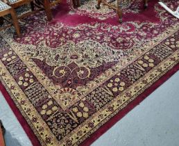 Large modern maroon ground Persian design carpet with large central floral medallion flanked by