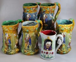 Five majolica pottery tower design jugs with dancing medieval relief moulded figures and entwined